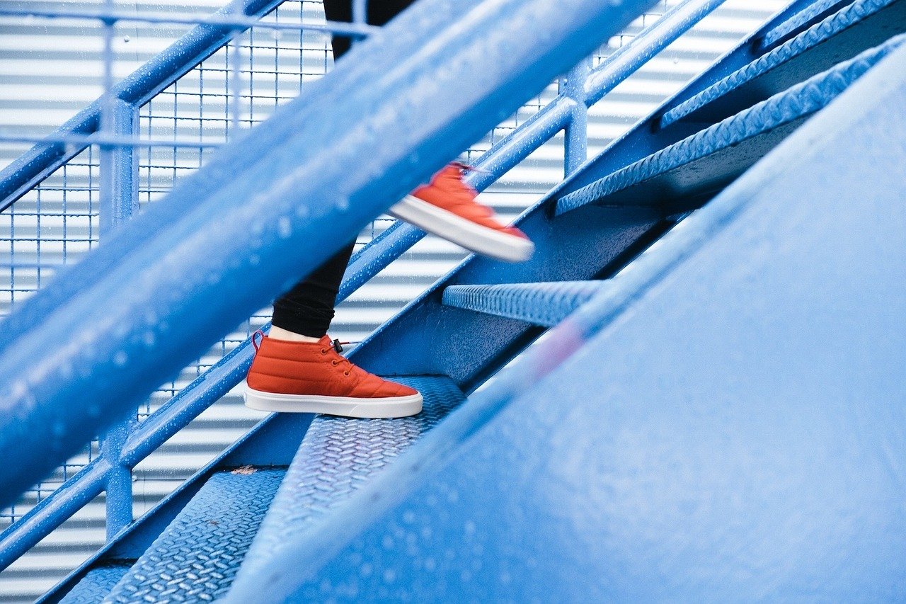 Treppen und Mensch mit roten Schuhen geht die Stufen hoch